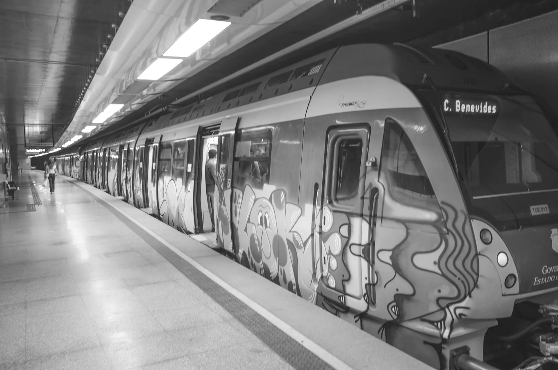 Fotografia em tons de cinza do trem todo grafitado na Estação de metrô do Benfica em Fortaleza